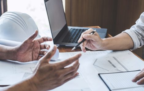 Deux hommes discutent dans un bureau à propos d'un chantier