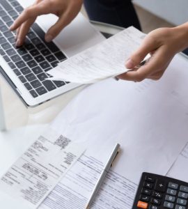 Vue de dessus d'une femme calculant des factures en utilisant un ordinateur portable