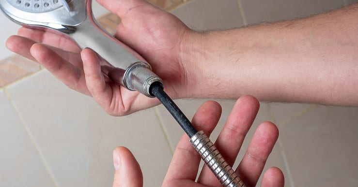 Pommeau de douche cassé dans les mains d 'un homme