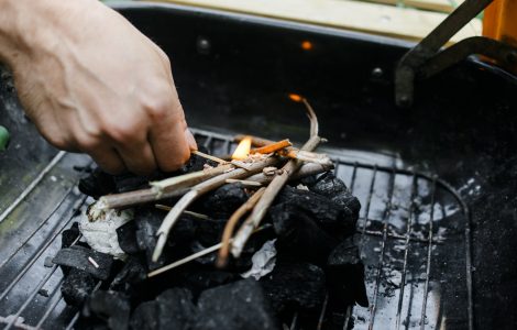 Un homme commence à allumer du charbon de bois pour le barbecue