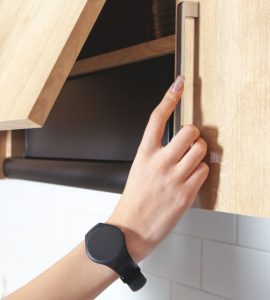 Zoom sur les mains d’une femme ouvrant un placard de cuisine en bois
