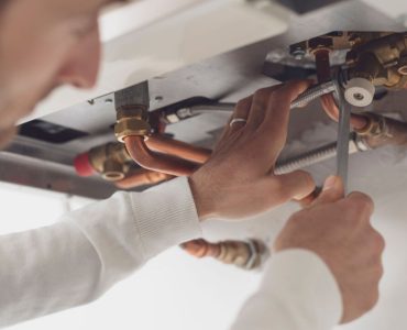 Un homme vérifie la chaudière et utilise une clé