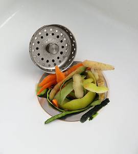 Zoom sur un évier de cuisine bouché par des épluchures de légumes