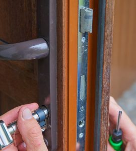 Gros plan sur un homme réparant la serrure d'une porte de maison