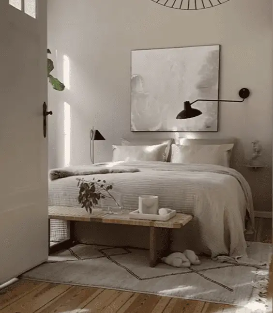 Un tapis à franges aux pieds du lit