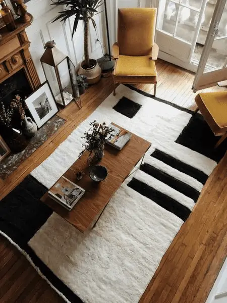Un tapis noir et blanc moelleux dans un petit salon boisé