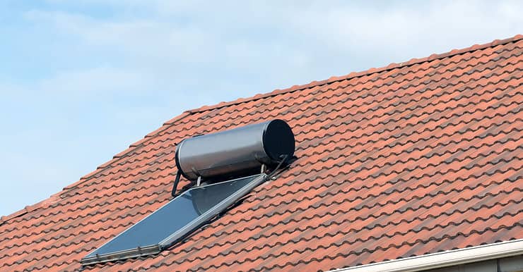 Une chauffe-eau solaire installée sur un toit en tuile