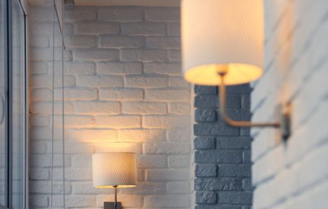 Lampes murales allumées, fixées sur un mur en briques