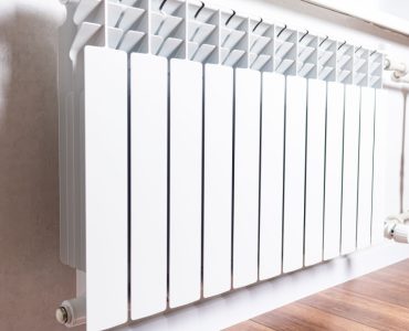 Radiateur de chauffage blanc sous la fenêtre