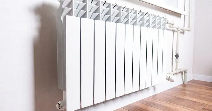 Radiateur de chauffage blanc sous la fenêtre