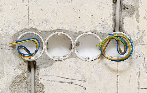 Des trous réalisés dans le mur en béton pour accueillir les prises électriques