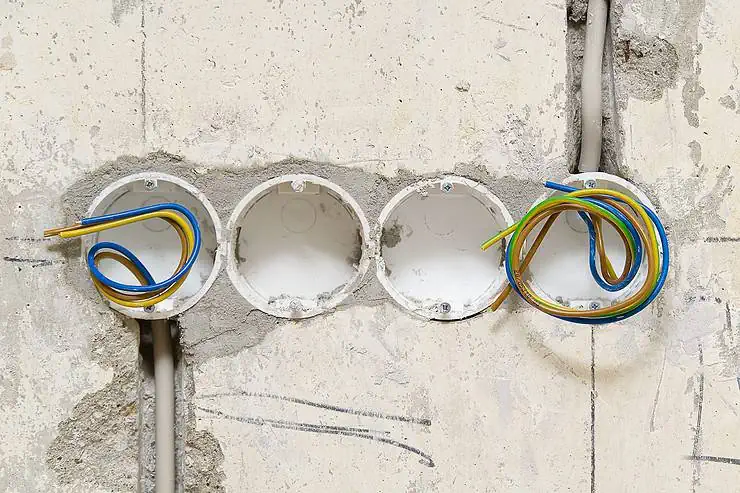 Des trous réalisés dans le mur en béton pour accueillir les prises électriques