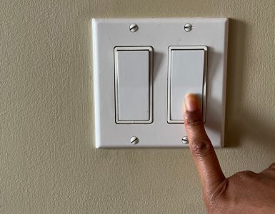 Zoom sur la main d'une personne appuyant sur un interrupteur