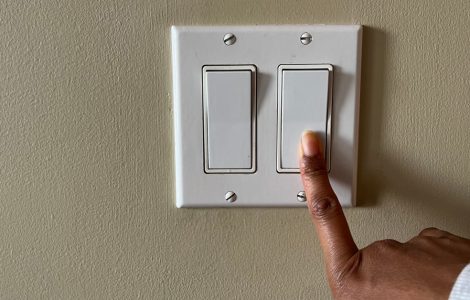 Zoom sur la main d'une personne appuyant sur un interrupteur