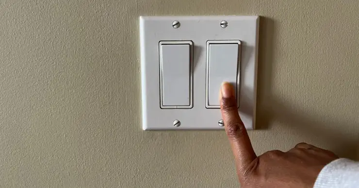Zoom sur la main d'une personne appuyant sur un interrupteur