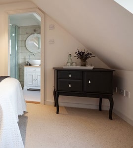 Une petite chambre à coucher sous pentes, avec salle de bain attenante
