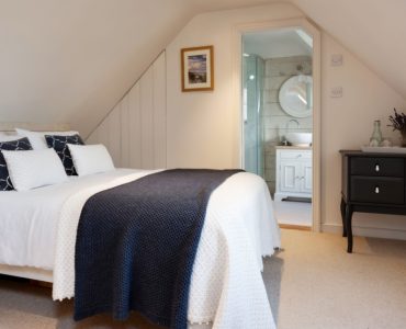 Une petite chambre à coucher sous pentes, avec salle de bain attenante