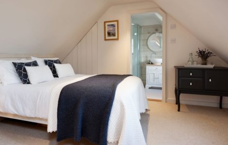 Une petite chambre à coucher sous pentes, avec salle de bain attenante