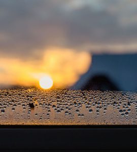 Des goutellettes d'eau qui s'accumulent sur le coin d'une fenêtre vitrée