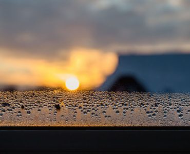 Des goutellettes d'eau qui s'accumulent sur le coin d'une fenêtre vitrée