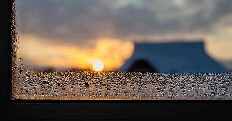 Des goutellettes d'eau qui s'accumulent sur le coin d'une fenêtre vitrée