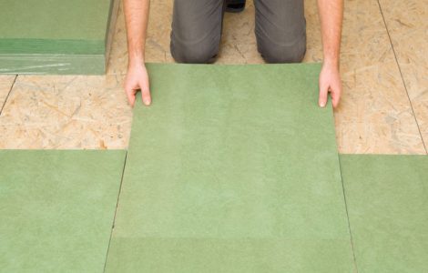 Focus sur un homme posant une planche d'isolation en fibre de bois naturel vert