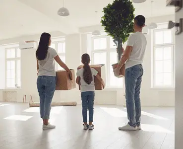 Un jeune couple avec un enfant arrivant dans un appartement vide