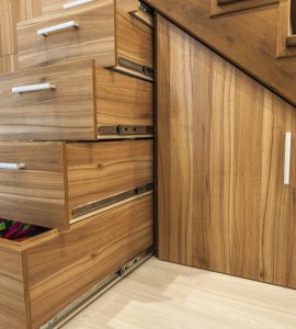 Des tiroirs de rangement sous les escaliers en bois
