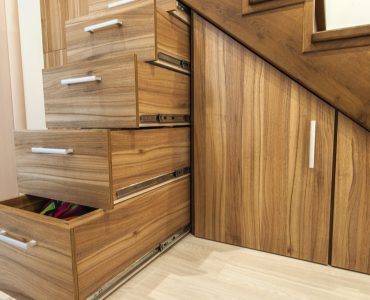Des tiroirs de rangement sous les escaliers en bois