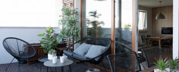 Terrasse avec mobilier en bois noir et quelques plantes