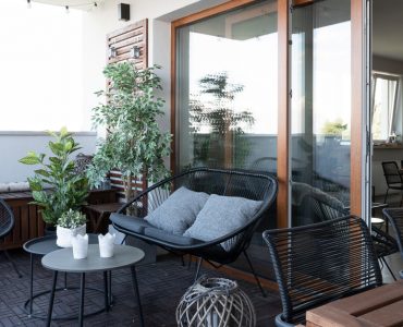 Terrasse avec mobilier en bois noir et quelques plantes