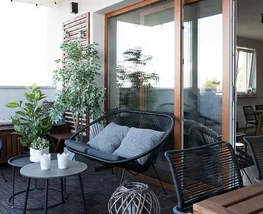 Terrasse avec mobilier en bois noir et quelques plantes