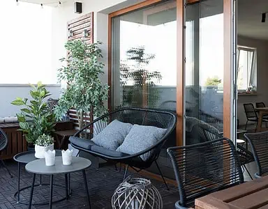 Terrasse avec mobilier en bois noir et quelques plantes