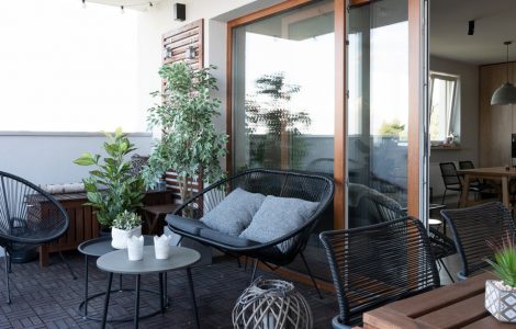 Terrasse avec mobilier en bois noir et quelques plantes
