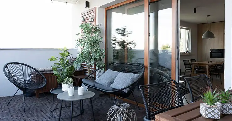 Terrasse avec mobilier en bois noir et quelques plantes