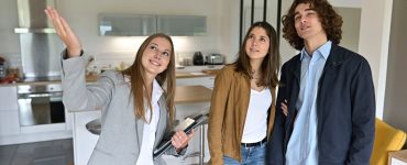 Une femme fait visiter un appartement à un jeune couple