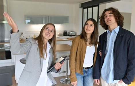 Une femme fait visiter un appartement à un jeune couple