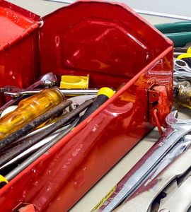 Une boîte à outils rouge remplie de clés et de tournevis