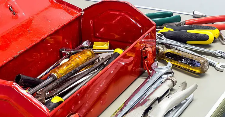 Une boîte à outils rouge remplie de clés et de tournevis
