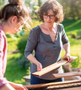 Une mère et ses deux enfants assemblant un panneau de bois