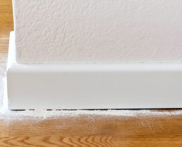 Poudre blanche versée entre le parquet et les plinthes