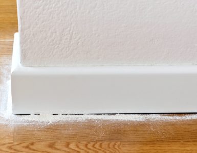 Poudre blanche versée entre le parquet et les plinthes