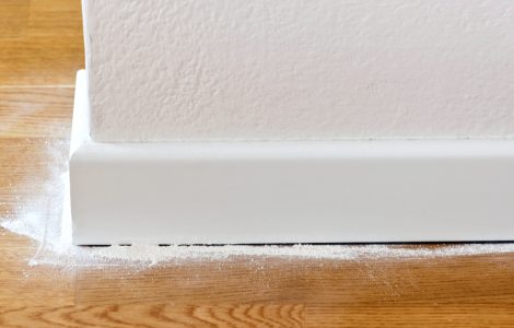 Poudre blanche versée entre le parquet et les plinthes