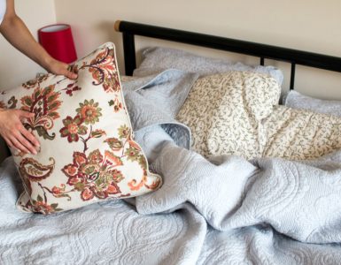 Gros plan sur les mains d'une femme faisant le lit dans une chambre