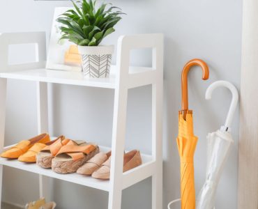 Un meuble à chaussures en bois blanc à l'entrée