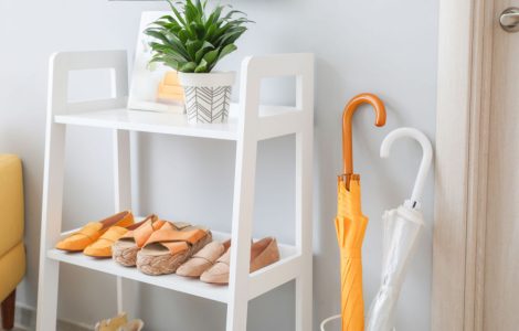 Un meuble à chaussures en bois blanc à l'entrée