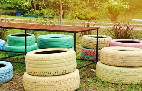 Des pneus colorés en guise de chaises de jardin autour d'une table en bois et en fer