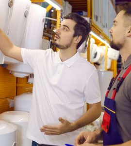 Deux hommes en train de discuter devant différents modèles de chauffage