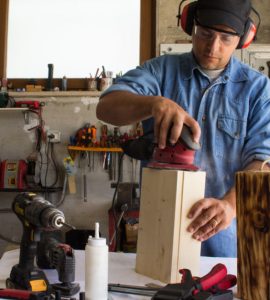 Un homme en train de travailler du bois dans son atelier de bricolage
