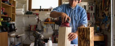 Un homme en train de travailler du bois dans son atelier de bricolage
